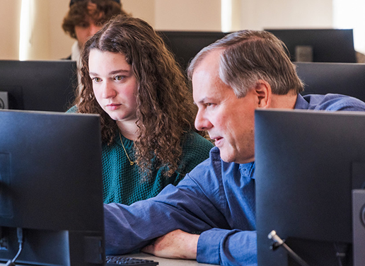 Professor working with student in computer lab