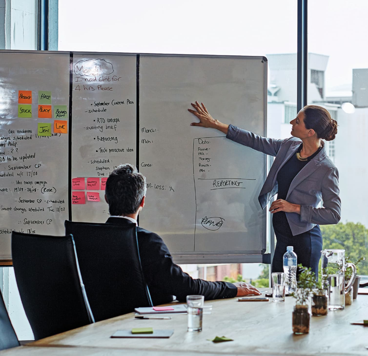 Woman standing at whiteboard in meeting