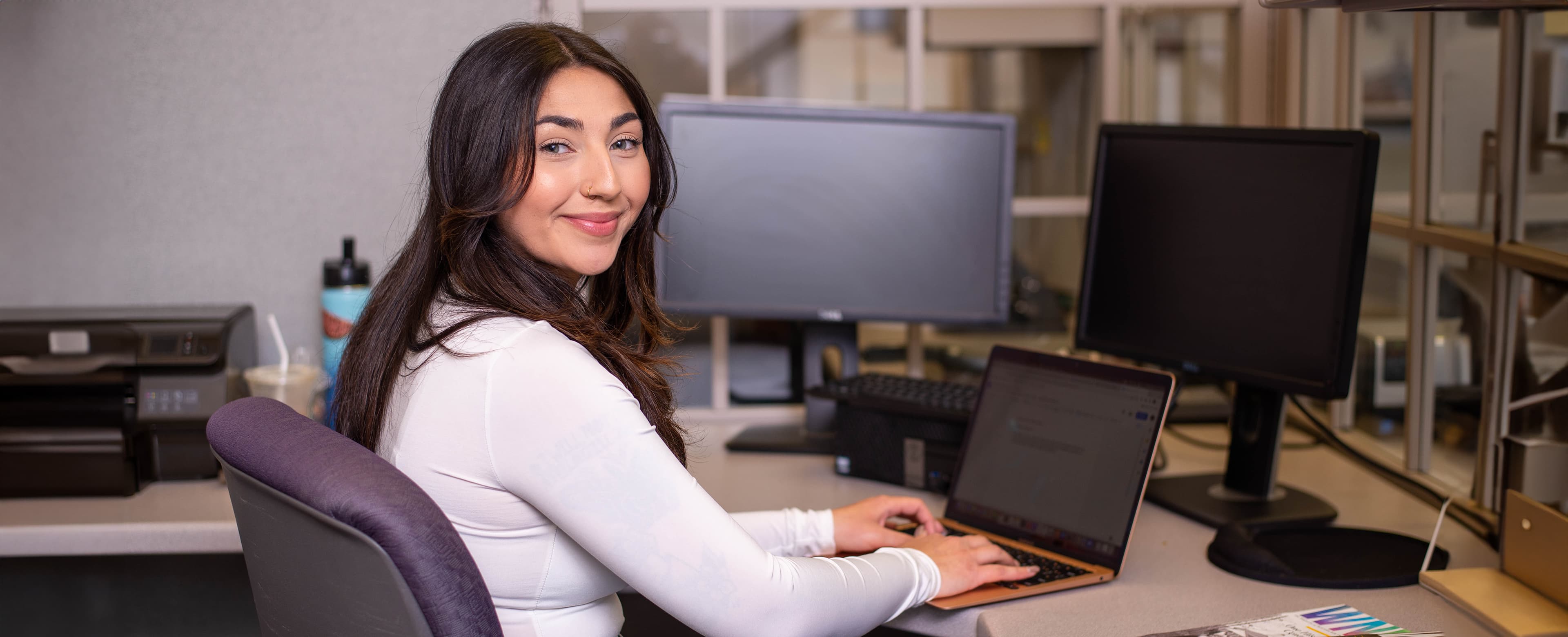 Female student sitting at computer and looking at camera