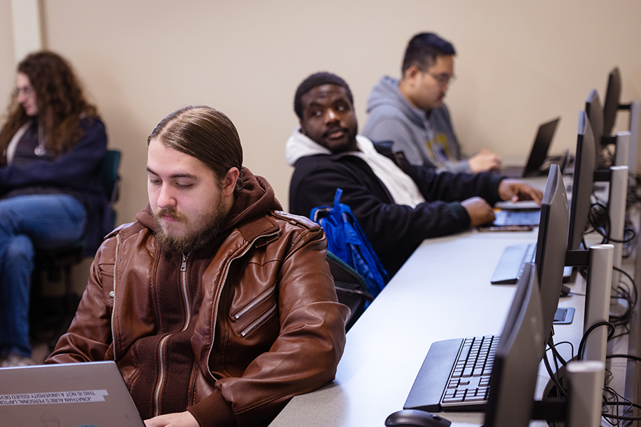 Student sitting with laptop in computer lab