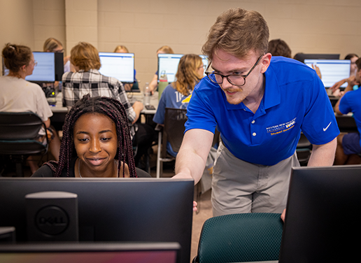 Advisor working with student at a computer