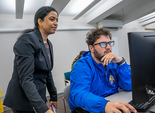 Professor working with student in computer lab