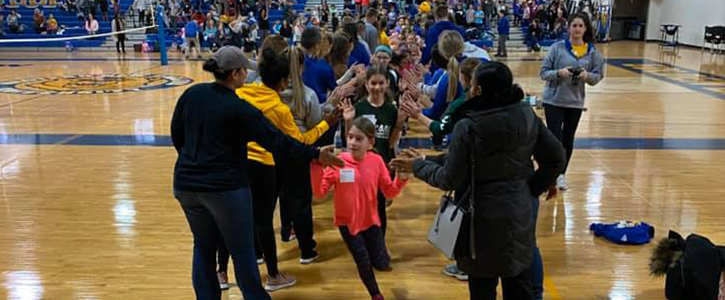Future athletes running through two lines of WNE athletes getting "high fived."