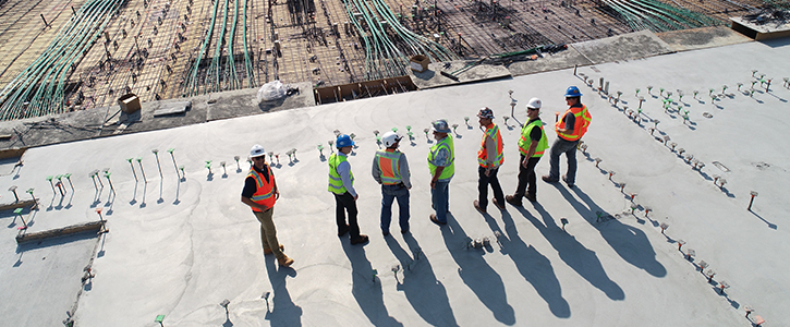 Seven people consulting at a construction site.