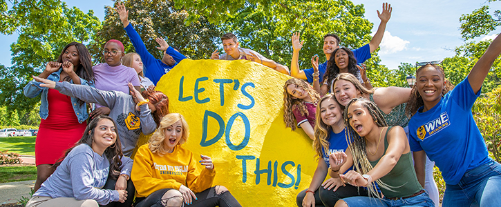 WNE students around the rock "Let's Do This"