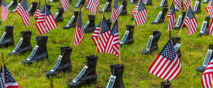 Military boots with flags sticking out of them to honor those who served