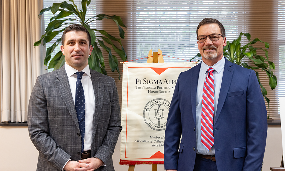 Hampden County District Attorney Anthony Gulluni stands with Don Williams Chair of History, Philosophy, Political Science & Economics at the 2024 Pi Sigma Alpha National Honor Society induction ceremony on April 18.