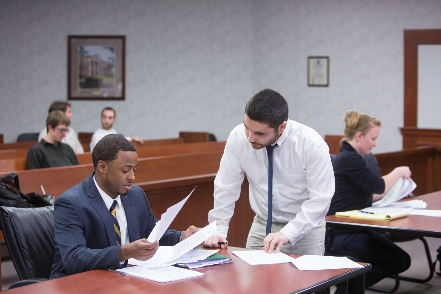 Law students consult notes in WNE School of Law moot courtroom