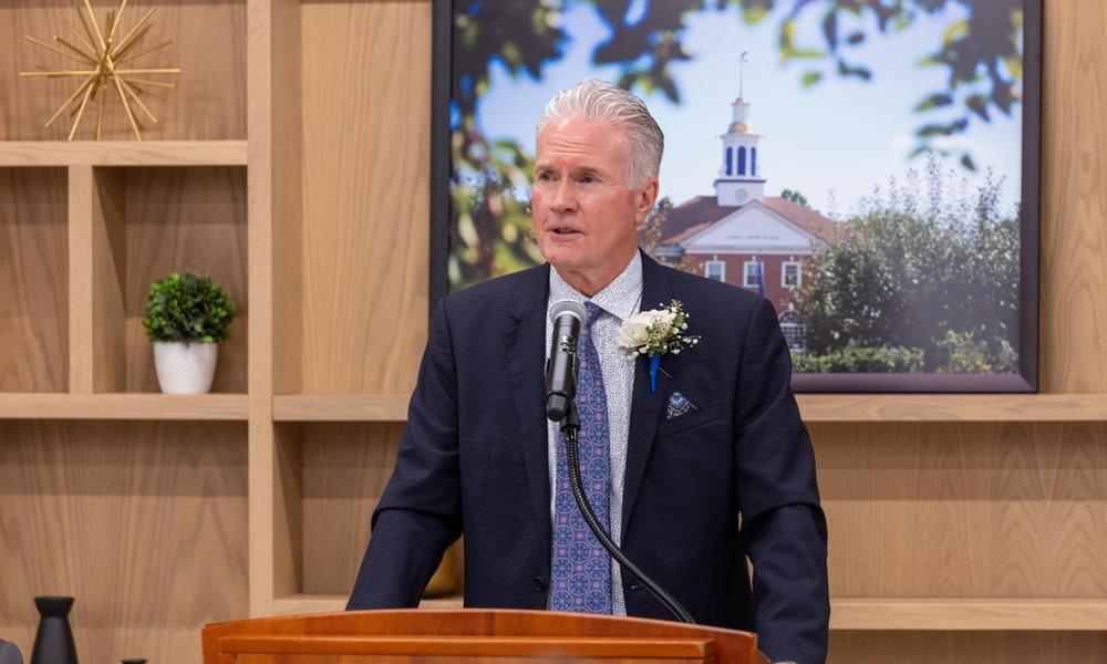 Kevin  Delbridge standing at a podium.