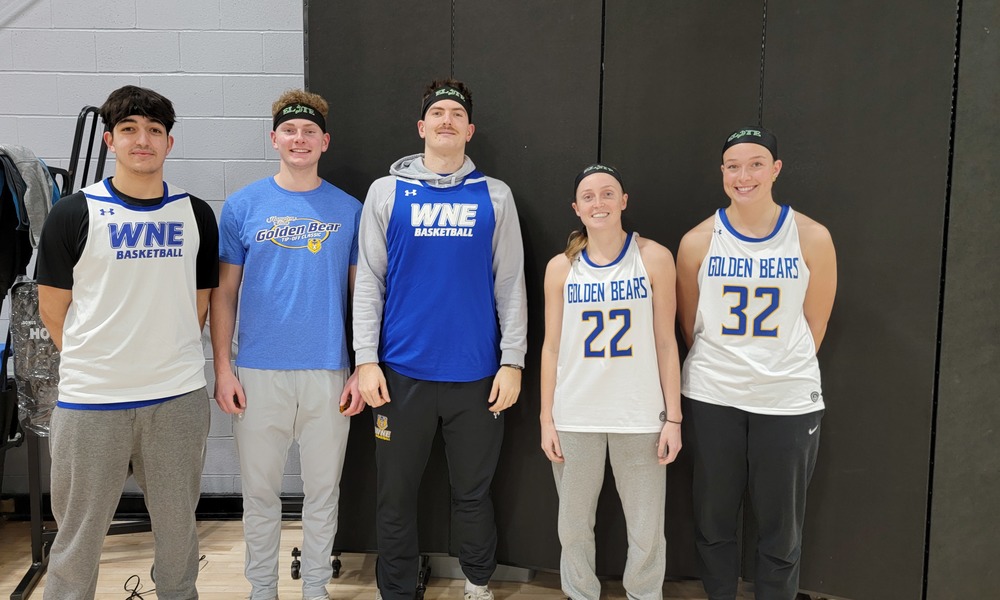 Five WNE basketball players, 3 men and 2 women, line up for a photo in jerseys and headbands.