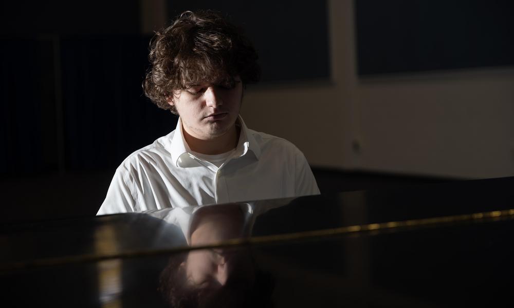 Ben Bedford performs on a baby grand piano