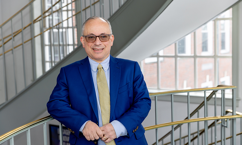 Mike Richichi standing in sunny hallway with staircase behind him.