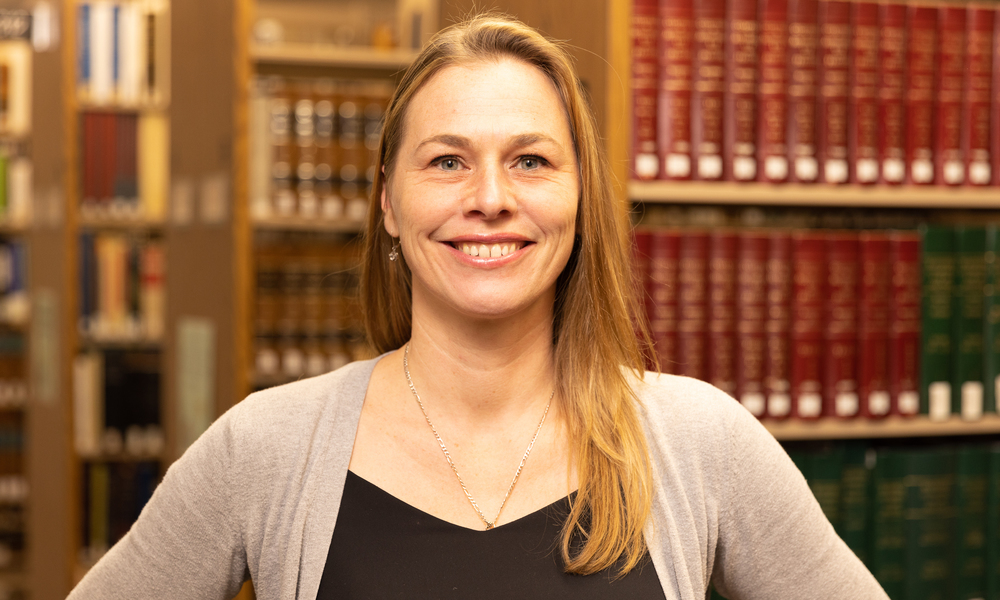 Head shot of Jordana Harper in front of law books.