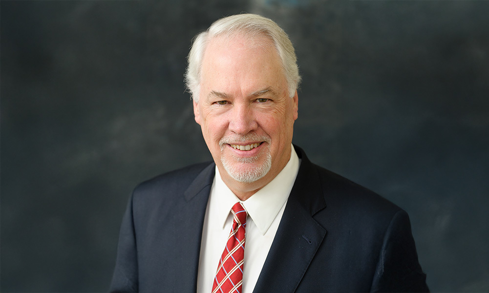 Headshot of Michael B. Alexander against a dark background.