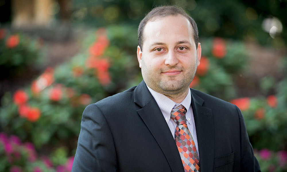 Head shot of Associate Professor Seyed Niknam under a blossoming tree