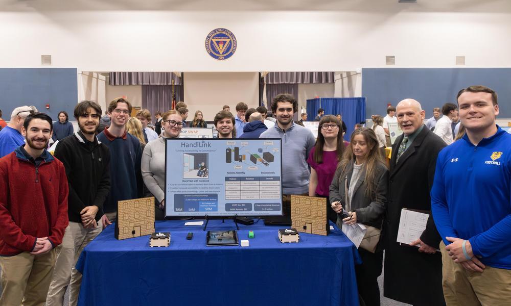Student designers of the Handilink concept standing around a prototype of the concept.