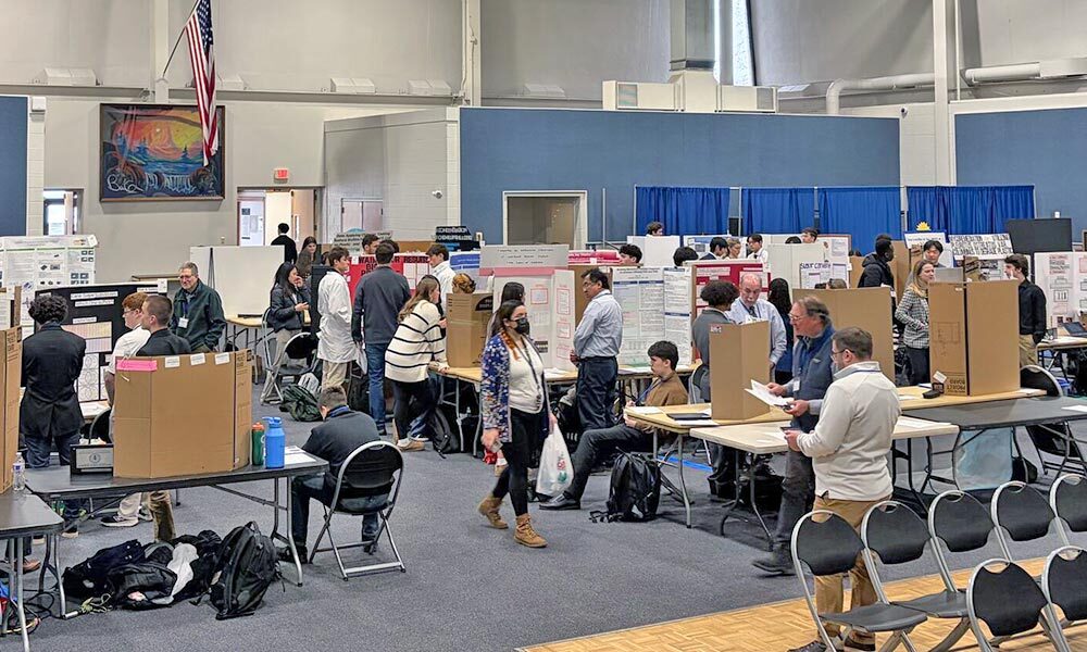 Wide view of students presenting poster presentations.