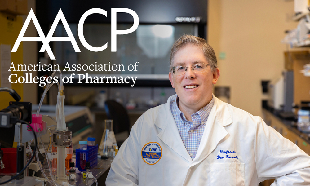 Photo of Dan Kennedy in a white lab coat that extends or bleeds to the edge of the photo with the AACP logo in the upper left corner.