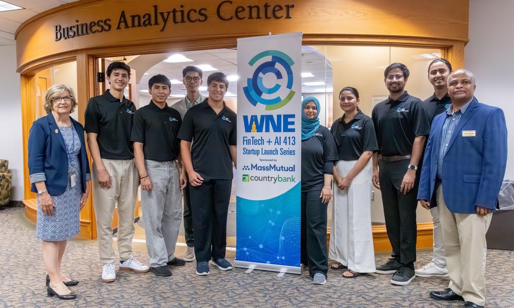 Faculty and students stand in front of the Business Analytics Center around the Fintech+AI signage.