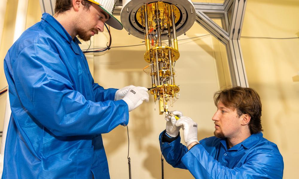 Two students work on the cryogenic refrigerator in WNE's quantum lab.