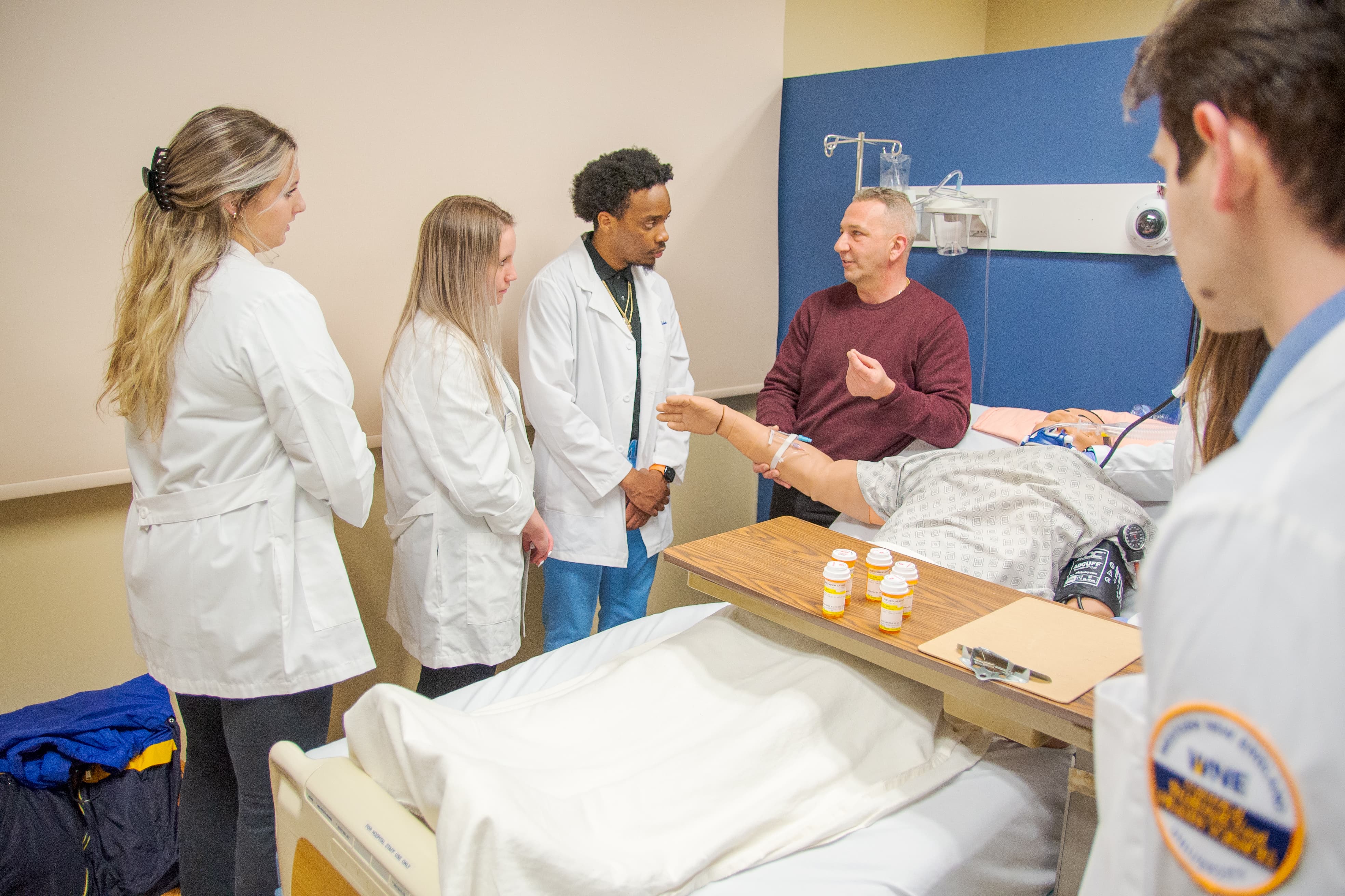 Professor with students in hospital setting
