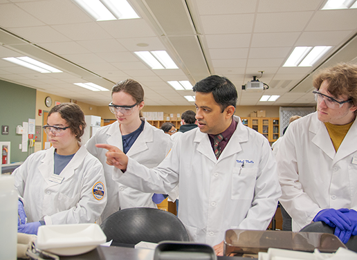 Faculty member working with students in pharmacy lab