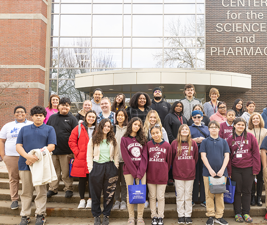 Duggan middle school students standing in front of Center for Sciences and Pharmacy