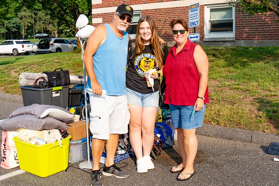 Female student standing with parents on move in day